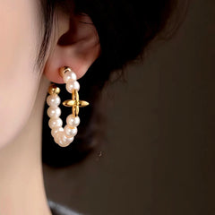 Model showcasing the dangle and style of the 14K Gold-Plated Star Pearl C-Shaped Earrings