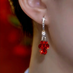 Model showcasing the dangle and style of the 14K Gold-Plated Super Shiny Red Crystal Water Drop Earrings