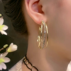 Model showcasing the dangle and style of the 14K Gold-Plated Three-Layer Diamond Hoop Earrings