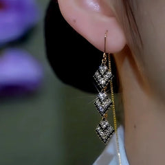 Model showcasing the dangle and style of the 14K Gold-Plated Tripple-Layer Black And White Diamond Threader Earrings