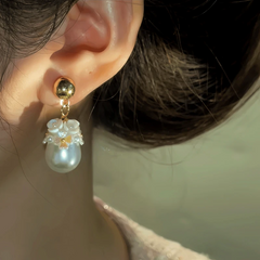 Model showcasing the dangle and style of the 14K Gold-Plated Water Drop Flower Pearl Earrings