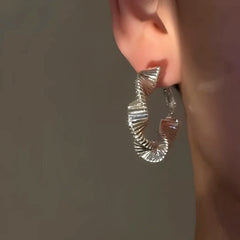 Model showcasing the dangle and style of the 14K Gold-Plated Wavy Hoop Earrings