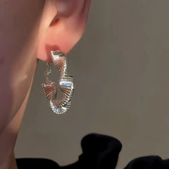 Close-up detail of the sparkling zircons and plating on the Wavy Hoop Earrings