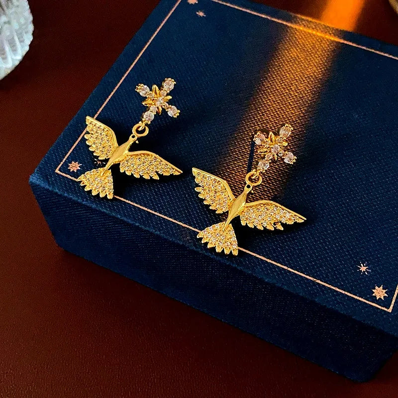 Model showcasing the dangle and style of the 14K Gold-Plated Zircon Bird Earrings