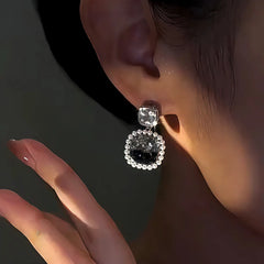 Model showcasing the dangle and style of the 14K Gold-Plated Zircon Black Crystal Earrings