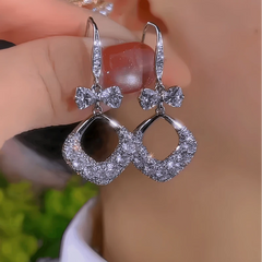 Model showcasing the dangle and style of the 14K Gold-Plated Zircon Bow Water Drop Ear Hook Earrings