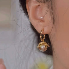 Model showcasing the dangle and style of the 14K Gold-Plated Zircon Brown Pearl Earrings