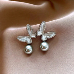 Angled view of the 14K Gold-Plated Zircon Butterfly Gray Pearl Earrings