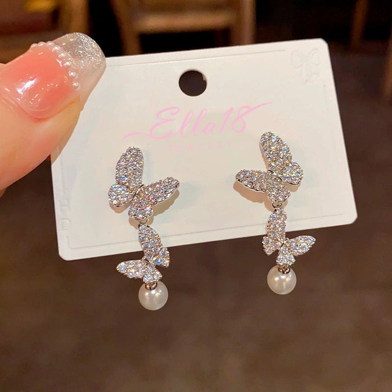 Model showcasing the dangle and style of the 14K Gold-Plated Zircon Butterfly Pearl Tassel Earrings