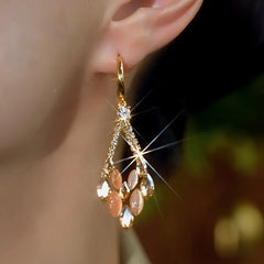 Model showcasing the dangle and style of the 14K Gold-Plated Zircon Cat's Eye Diamond Earrings