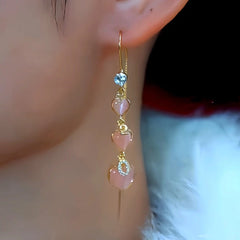 Model showcasing the dangle and style of the 14K Gold-Plated Zircon Cat's Eye Stone Heart Threader Earrings