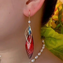 Model showcasing the dangle and style of the 14K Gold-Plated Zircon Colored Feather Earrings