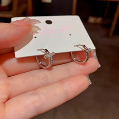 Close-up detail of the sparkling zircons and plating on the Cross Hoop Earrings