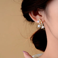 Model showcasing the dangle and style of the 14K Gold-Plated Zircon Cross Pearl Earrings
