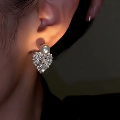 Model showcasing the dangle and style of the 14K Gold-Plated Zircon Crystal Heart Gray Pearl Earrings