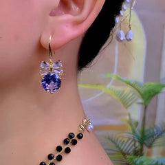Model showcasing the dangle and style of the 14K Gold-Plated Zircon Diamond Bow Ear Hook Earrings