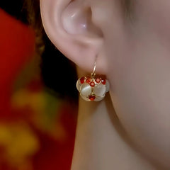 Close-up detail of the sparkling zircons and plating on the red drop earrings