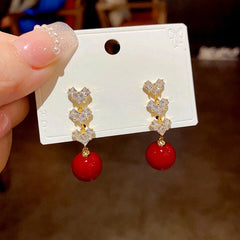 Angled view of the 14K Gold-Plated Zircon Diamond Heart Pearl Tassel Earrings