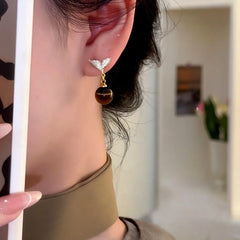 Model showcasing the dangle and style of the 14K Gold-Plated Zircon Diamond Mermaid Tail Bead Earrings