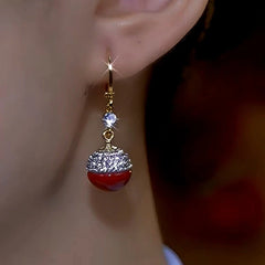Close-up detail of the sparkling zircons and plating on the Red Pearl Earrings