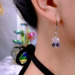 Elegant purple crystal drop dangle earring with gold hook worn on woman's ear