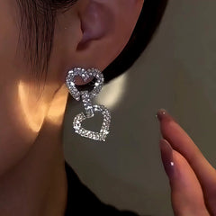 Model showcasing the dangle and style of the 14K Gold-Plated Zircon Double-Heart Earrings