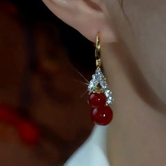 Model showcasing the dangle and style of the 14K Gold-Plated Zircon Double Wine Pearl Bottle Earrings
