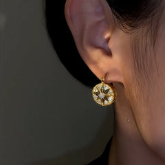 Model showcasing the dangle and style of the 14K Gold-Plated Zircon Eight-Pointed Star Compass Earrings