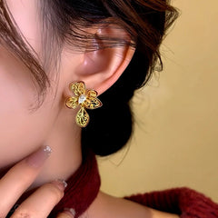 Model showcasing the dangle and style of the 14K Gold-Plated Zircon Enamel Filigree Flower Earrings
