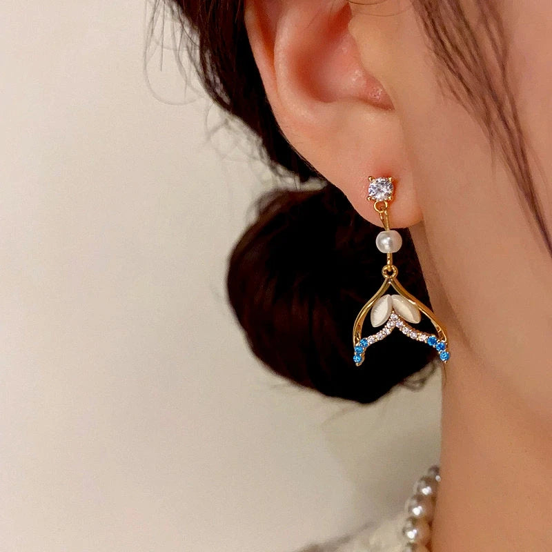 Close-up detail of the sparkling zircons and plating on the Fishtail Pearl Earrings