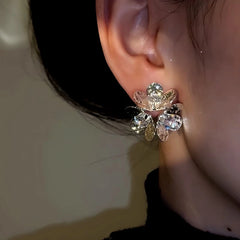 Model showcasing the dangle and style of the 14K Gold-Plated Zircon Flower Earrings