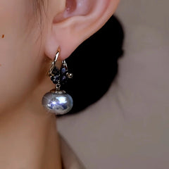 Model showcasing the dangle and style of the 14K Gold-Plated Zircon Flower Oval Pearl Earrings