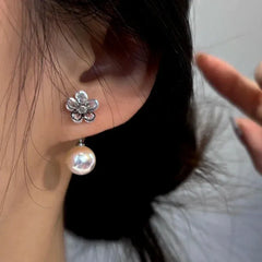 Model showcasing the dangle and style of the 14K Gold-Plated Zircon Flower Pearl Jacket Earrings