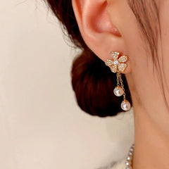 Model showcasing the dangle and style of the 14K Gold-Plated Zircon Flower Pearl Tassel Earrings