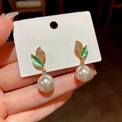 Angled view of the 14K Gold-Plated Zircon Green Leaf Pearl Earrings
