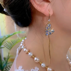 Model showcasing the dangle and style of the 14K Gold-Plated Zircon Heart Ear Hook Tassel Earrings