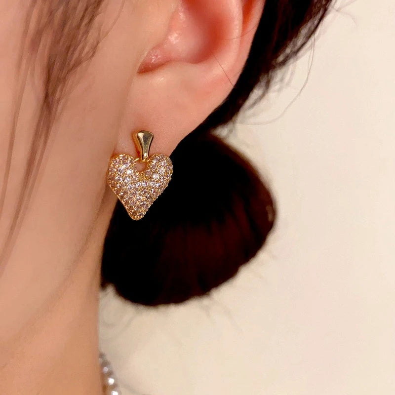 Model showcasing the dangle and style of the 14K Gold-Plated Zircon Heart Earrings