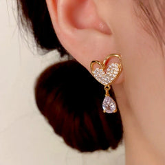 Model showcasing the dangle and style of the 14K Gold-Plated Zircon Heart Tassel Earrings