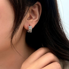 Model showcasing the dangle and style of the 14K Gold-Plated Zircon Leaf Hoop Earrings
