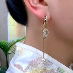 Model showcasing the dangle and style of the 14K Gold-Plated Zircon Leaf Pearl Earrings