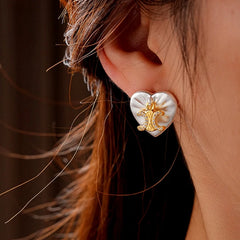 Model showcasing the dangle and style of the 14K Gold-Plated Zircon Letter Heart Stud Earrings