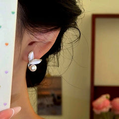 Model showcasing the dangle and style of the 14K Gold-Plated Zircon Mermaid Tail Pearl Earrings