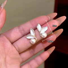 Angled view of the 14K Gold-Plated Zircon Mermaid Tail Pearl Earrings