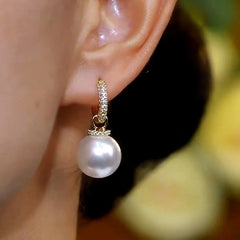 Model showcasing the dangle and style of the 14K Gold-Plated Zircon Pearl Earrings