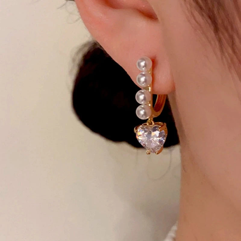 Model showcasing the dangle and style of the 14K Gold-Plated Zircon Pearl Earrings