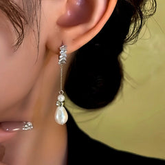 Side view of silver baguette crystal teardrop pearl dangle earring on female ear