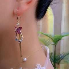 Close-up of purple butterfly gold crystal tassel drop earring on ear