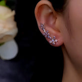 Purple rhinestone flower ear climber earring worn on right ear