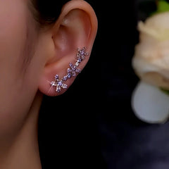 Purple rhinestone flower ear climber earring worn on left ear