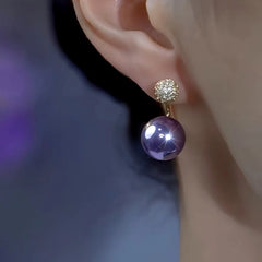 Model showcasing the dangle and style of the 14K Gold-Plated Zircon Purple Pearl Earrings